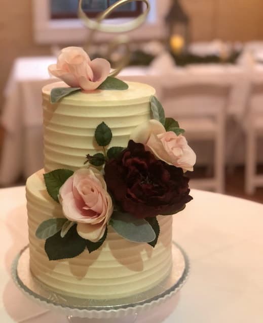 Tall white tiered wedding cake with piping